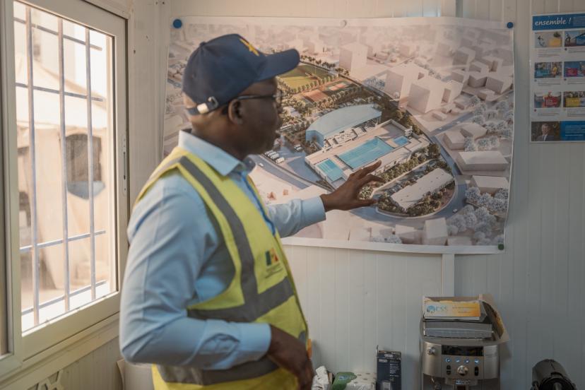 Babacar Senghor, coordonnateur du projet des Jeux Olympiques de la Jeunesse (JOJ), devant les plans de la piscine. (S. Cherkaoui/L'Équipe)