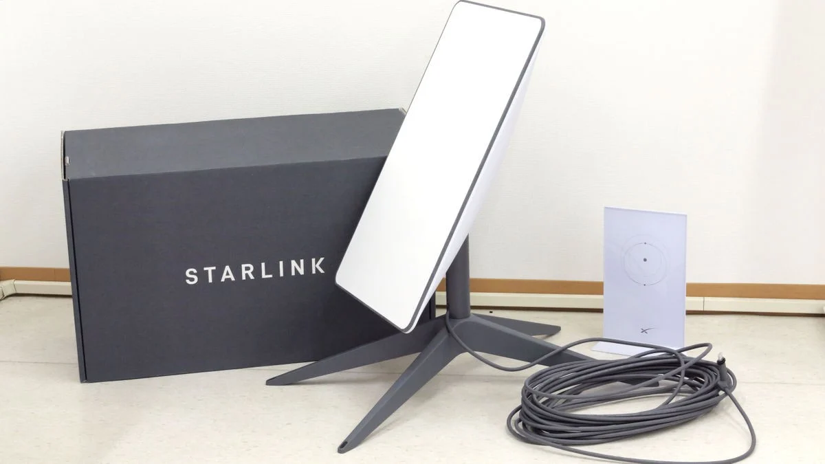 Starlink internet router on a wooden table with African sunset in background