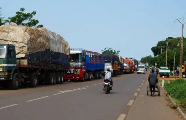 Negotiators from Benin and Niger shake hands during border reopening talks in Cotonou