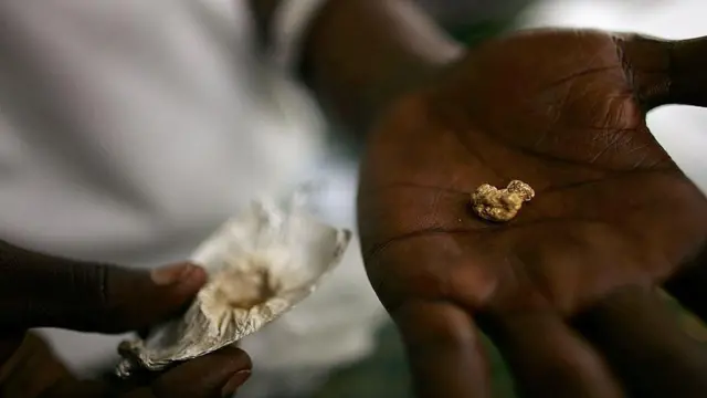 An individual holds a gold nugget in their palm