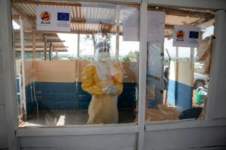 Health workers in protective gear attending to Ebola patients in a treatment center