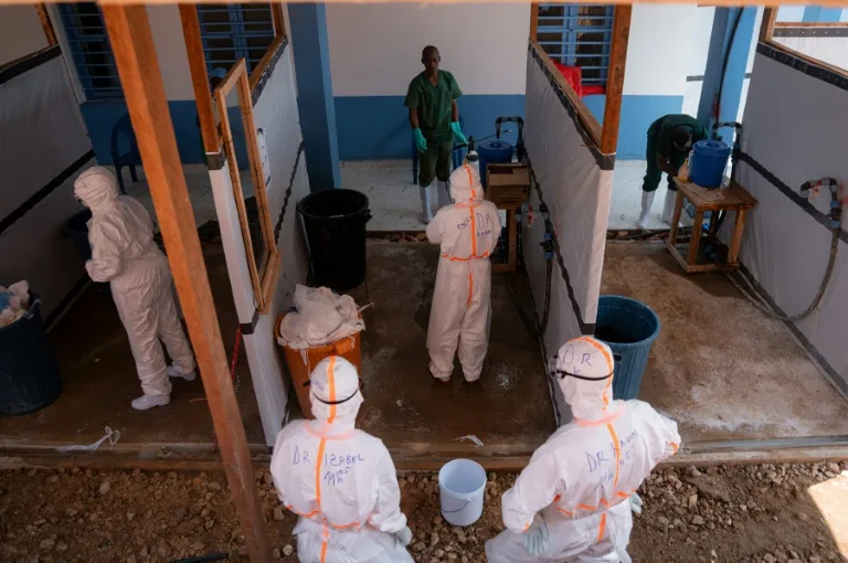 Health workers in protective gear treating patients