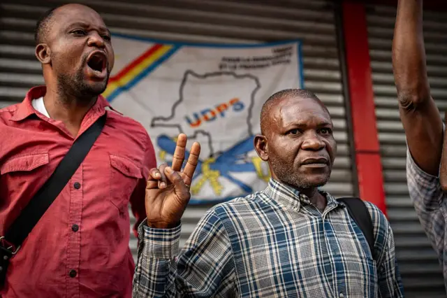 Deux militants de l'Union pour la démocratie et le progrès social (UDPS), le parti présidentiel, scandent des slogans en l'honneur du président Félix Tshisekedi à Kinshasa, le 27 mars 2026.